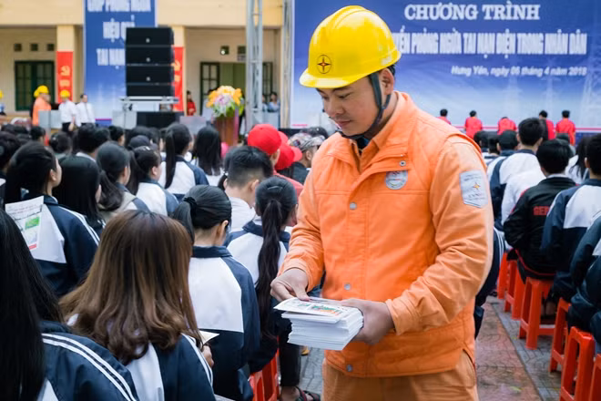 Cán bộ điện lực Hưng Yên phát tờ rơi hướng dẫn, cảnh báo cho các em học sinh.