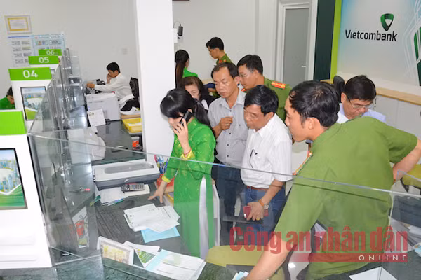 Các nhân viên bị khống chế tại quầy giao dịch. Trong ảnh nữ nhân viên ngân hàng báo về tổng đài để trích xuất camera an ninh.