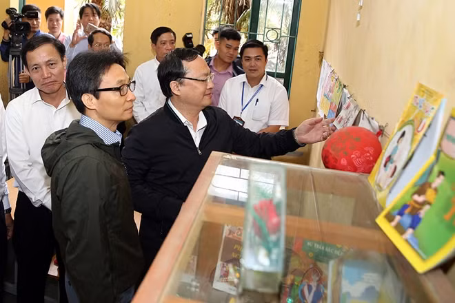Phó Thủ tướng Vũ Đức Đam và Bí thư Tỉnh uỷ Hưng Yên Đỗ Tiến Sỹ thăm một tủ sách lớp em ở trường tiểu học Dạ Trạch. Ảnh: VGP/Đình Nam