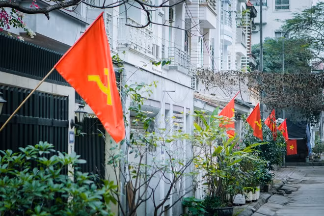 Tại một khu dân cư nằm gần Học viện ANND, người dân không chỉ treo cờ đỏ sao vàng mà còn có cả những lá cờ Đảng kề bên.