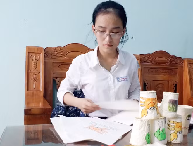 Em Duyên bên các sản phẩm làm từ giấy chống thấm.