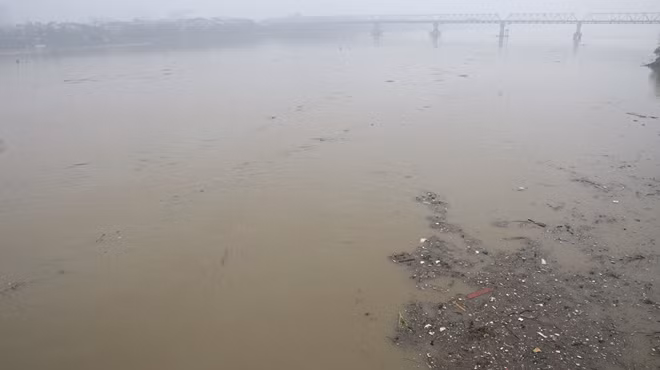 Rác trôi nổi trên mặt sông, tầm nhìn hướng về cầu Chương Dương.