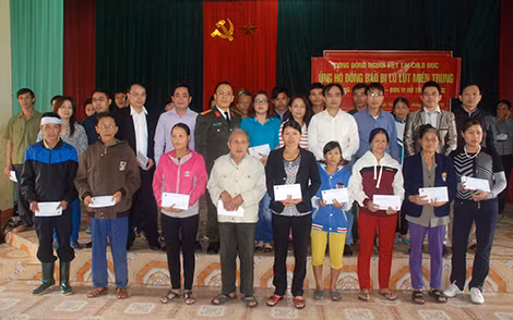 Đại diện Cộng đồng người Việt tại CHLB Đức và Báo CAND tặng quà tới đồng bào vùng lũ Hương Khê (mỗi suất trị giá 1 triệu đồng)