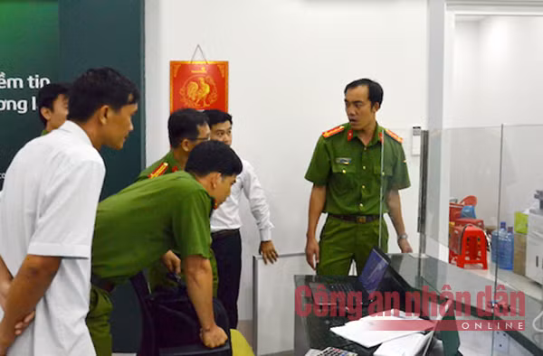 Cán bộ điều tra đang xem lại camera an ninh, ghi lại cảnh nghi phạm khống chế nhân viên cướp ngân hàng.