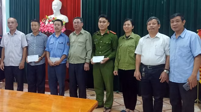 Lãnh đạo thị trấn Nông trường Việt Trung khen thưởng những người dân dũng cảm trên địa bàn đã phối hợp cùng với lực lượng Công an cứu xe khách bị trôi.