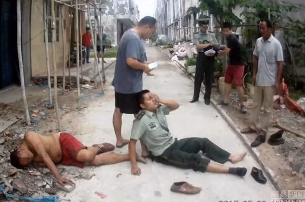 Sĩ quan cảnh sát Liang Xiao (phải) bị thương nặng sau khi làm lá chắn đỡ người nhảy lầu tự tử.