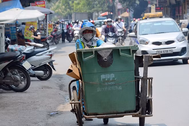 Nữ công nhân vệ sinh cũng vì thế mà vất vả hơn để thu gom rác trên đường phố trong ngày nắng nóng.