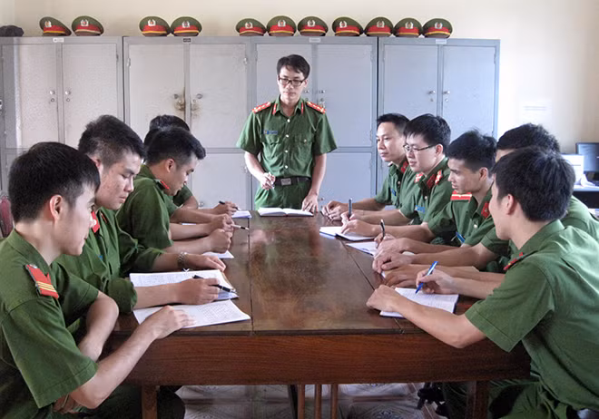 Đại úy Nguyễn Xuân Điệp (đứng) đang họp bàn kế hoạch phá án với các trinh sát Công an huyện Văn Bàn.