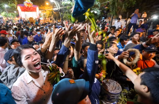 Bên trong sân hành lễ đông nghẹt người, ai cũng cố gắng giờ tay thật cao lên lễ đài để nhận đồ cúng. Theo nghi lễ truyền thống, người nào được một chút đồ làm lễ cũng có lộc, mang lại sự may mắn, phát tài.
