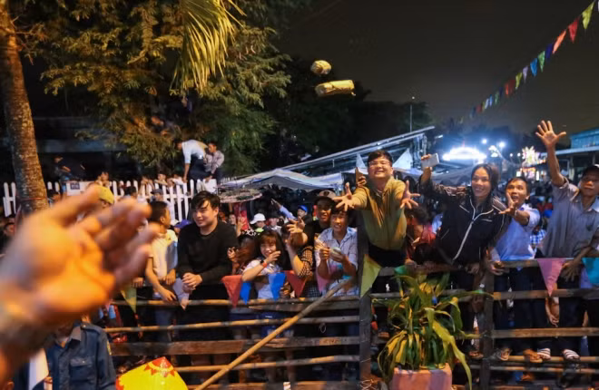 Những thành viên trong ban lễ hội bắt đầu ném đồ cúng như trái cây, hoa, bánh kẹo, thịt… cho người ở bên ngoài.
