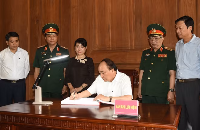 Thủ tướng ghi sổ lưu niệm tại Khu Di tích K9. Ảnh: VGP/Quang Hiếu