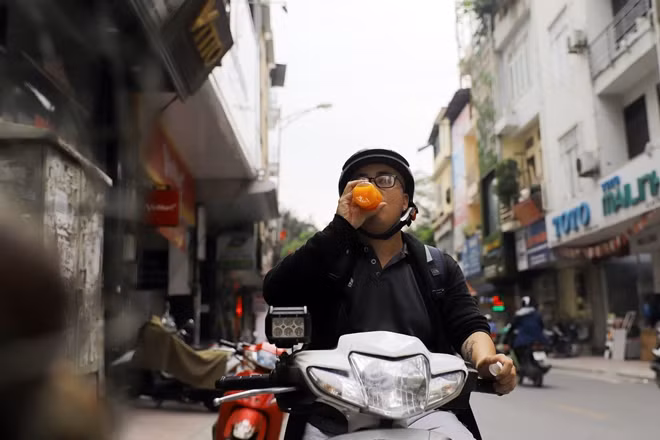 Một bạn trẻ trên đường đi ghé vào mua nước cam ép uống luôn tại chỗ rồi lại tiếp tục hành trình.