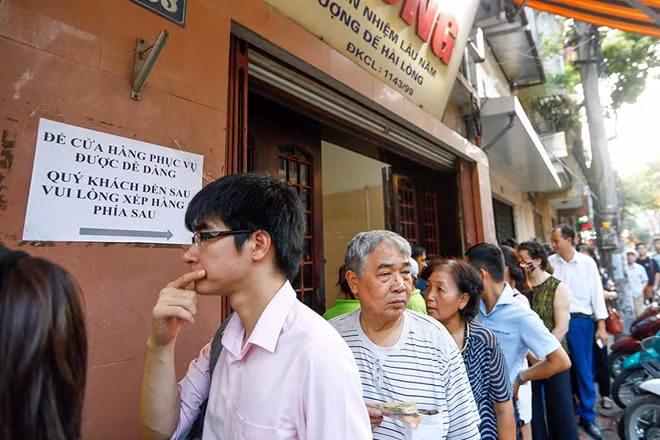 Do đã có chỉ dẫn nên khách hàng cũng "đành" phải ra sau, nhiều người rất sốt ruột nhưng không biết làm thế nào ngoài việc xếp hàng.