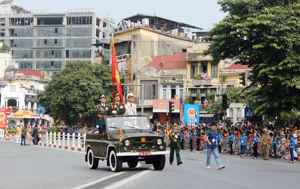 Tại ngã 7 Cửa Nam, đoàn diễu binh đi qua trong những tràng pháo tay nồng nhiệt của người dân. Ảnh: Quỳnh Vinh.