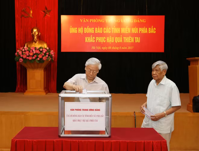Tổng Bí thư Nguyễn Phú Trọng, nguyên Tổng Bí thư Lê Khả Phiêu tham gia quyên góp ủng hộ đồng bào các tỉnh miền núi phía Bắc. Ảnh: TTXVN.