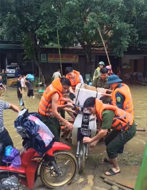 Cán bộ , chiến sỹ Công an huyện Mai Châu, Hòa Bình phối hợp với các lực lượng vận chuyển tài sản của người dân qua vùng ngập lụt.