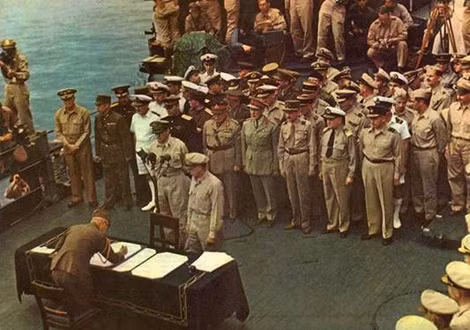 Đại diện Nhật Bản ký văn kiện đầu hàng Đồng minh vô điều kiện trên chiến hạm Missouri. Người đứng sau micro là Thống tướng Douglas MacArthur.