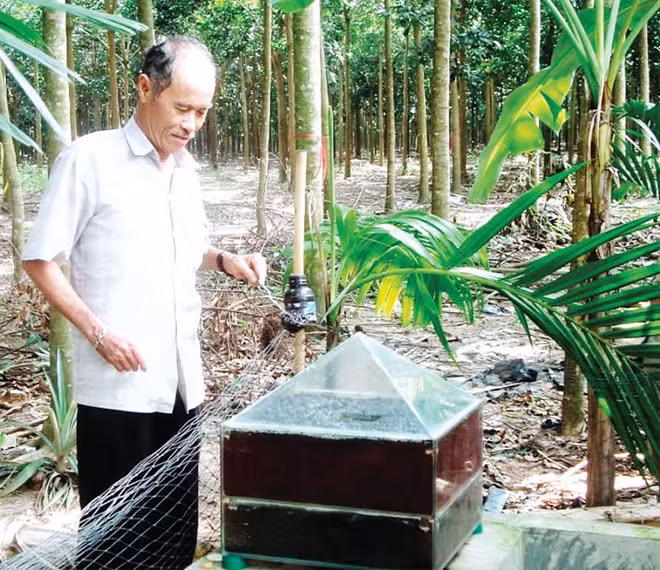 Ông Mai Văn Cúc bên “Bẫy sinh học diệt ruồi vàng” - Ảnh: Đức Trí.