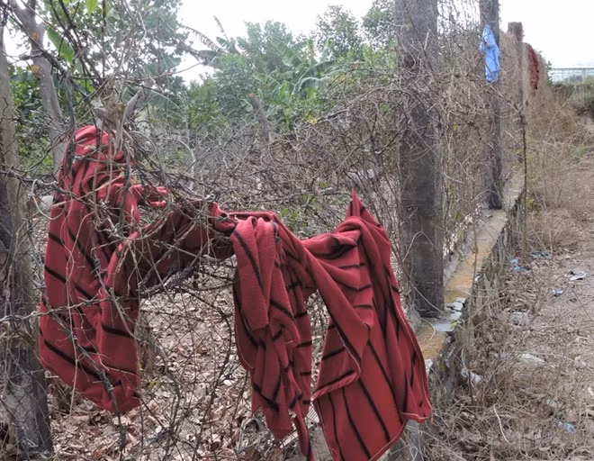 Học viên dùng mền phủ lên trên kẻm gai để trèo qua