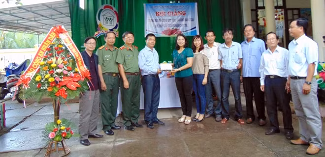 Đại diện đơn vị tài trợ trao tiền hỗ trợ cho lãnh đạo nhà trường.