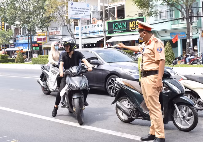 Cảnh sát giao thông nhắc nhở người dân, thực hiện việc đeo khẩu trang khi ra đường.