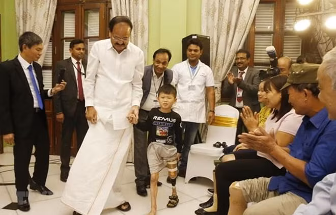 Phó Tổng thống Ấn Độ Venkaiah Naidu với người khuyết tật được lắp chân giả của hai tỉnh Quảng Ninh và Yên Bái. (Ảnh: Lâm Khánh/TTXVN)