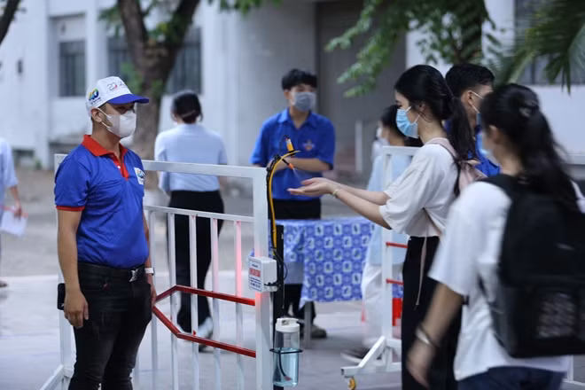 Các thí sinh được kiểm tra thân nhiệt, sát khuẩn tay trước khi vào phòng thi.