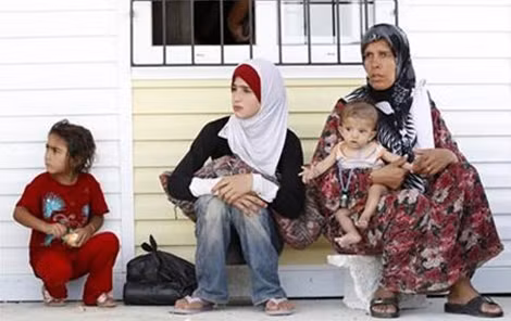 Bé gái Syria chạy nạn cùng gia đình.