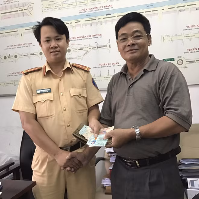 Hai anh Nguyễn Văn Hoàng và Bùi Văn Khoa được các chiến sĩ CSGT Công an TP. Đà Nẵng trao trả lại tài sản bị đánh rơi.