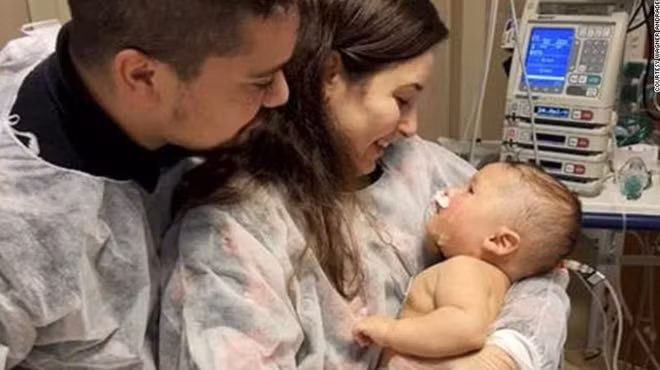 Cậu bé Dom tỉnh lại sau 32 ngày hôn mê vì nhiễm COVID-19. Ảnh: CNN.