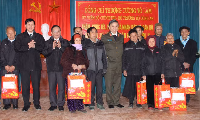 Bộ trưởng Tô Lâm và lãnh đạo tỉnh Sơn La tặng quà các gia đình có công với cách mạng tại xã Lóng Luông, huyện Vân Hồ, tỉnh Sơn La. Ảnh: TTXVN.