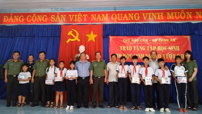 Đại tá Đỗ Văn Quang, Phó Cục trưởng Cục Hậu Cần trao tặng tập vở cho các em học sinh nghèo.