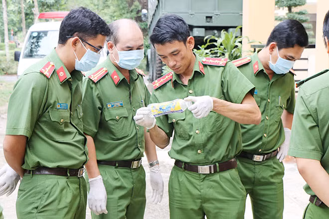 Đại úy Bùi Văn Thăng cùng đồng đội kiểm tra dấu vết trên vỏ chai nhựa.