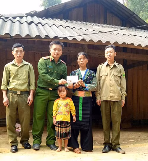 Đại diện Công an huyện Mù Cang Chải trao số tiền 1 triệu đồng của Báo CAND cho gia đình nạn nhân Thào A Lâu.