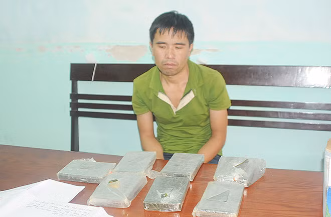 Lò Văn Si cùng tang vật là 7 bánh heroin tại cơ quan Công an.