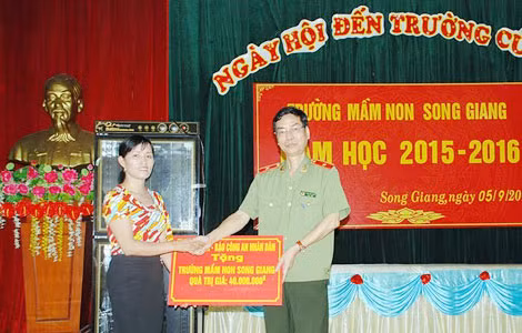 Thiếu tướng, TS Phạm Văn Miên, Tổng biên tập Báo CAND trao quà của nhà tài trợ cho Trường mầm non Song Giang.