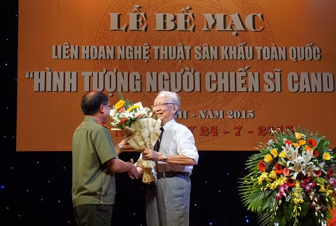 Phần đánh giá kết quả của GS Tất Thắng, Nhà Lý luận - Phê bình Sân khấu, Chủ tịch Hội đồng Giám khảo luôn bị ngắt quãng bởi những tràng pháo tay của khán giả. (Ảnh Trung tướng Bùi Bá Định, Phó tổng Cục trưởng Tổng cục Chính trị CAND, Trưởng Ban tổ chức tặng hoa GS Tất Thắng).