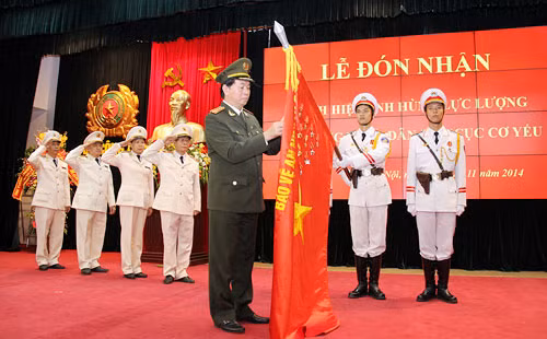 Đại tướng Trần Đại Quang gắn Huy hiệu Anh hùng lực lượng vũ trang nhân dân lên cờ truyền thống của Cục Cơ yếu.