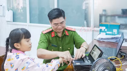 Cán bộ Phòng CSQLHC về TTXH thu nhận dữ liệu vân tay để làm căn cước cho trẻ em. 