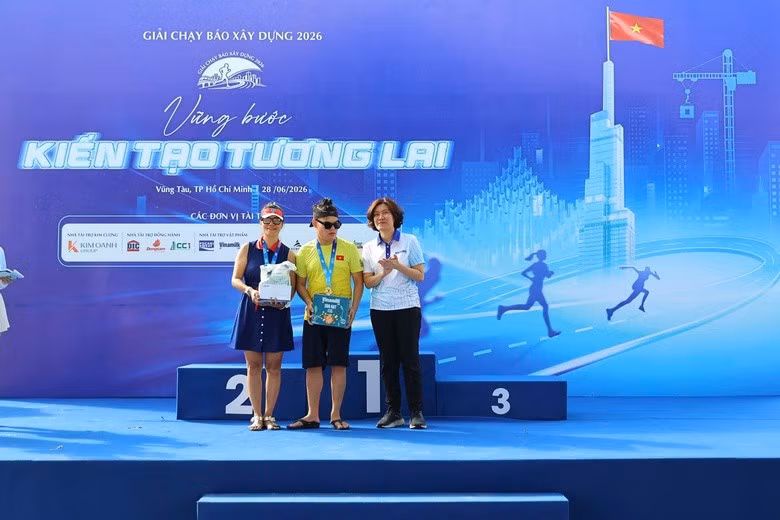 Nhà báo Nguyễn Thị Hồng Nga, Tổng Biên tập Báo Xây dựng, Trưởng Ban Tổ chức Giải trao phần quà "Hành trình yêu thương" tới chị Nguyệt Bùi và em Nguyễn Trọng Việt.