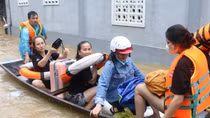 Công an lội nước đẩy thuyền giúp người dân thoát khỏi vùng ngập lụt nguy hiểm