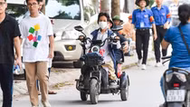 Hai cha con mắc bệnh xương thuỷ tinh chở nhau trên xe ba bánh tới điểm thi