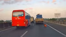 Cuộn bạt trên xe tải rơi xuống đường khiến ô tô khác suýt mất kiểm soát