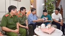 Bé trai con thương binh CAND xúc động nhận trái bóng do Bộ trưởng Tô Lâm trao tặng