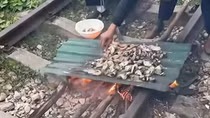 Vợ chồng đốt củi nướng thịt cá trên đường sắt, con gái quay clip tung lên mạng