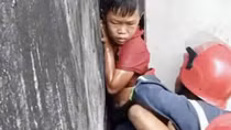 20 phút nghẹt thở giải cứu bé trai mắc kẹt giữa vách 2 căn nhà