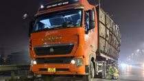 Xe đầu kéo chở hàng cao ngất ngưởng, ngả nghiêng đi ra đường