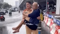 Cán bộ Phòng CSGT Công an TP Hà Nội giúp người nhiều dân đi điều trị bệnh trong mưa bão