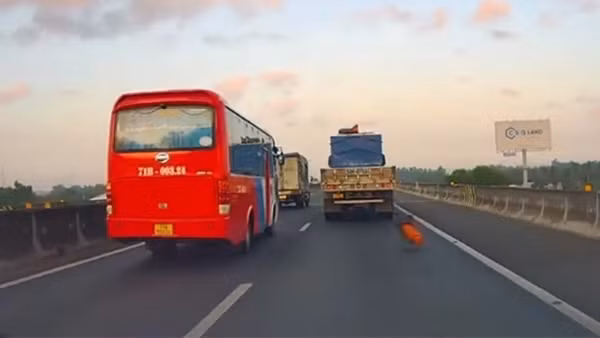 Cuộn bạt trên xe tải rơi xuống đường khiến ô tô khác suýt mất kiểm soát