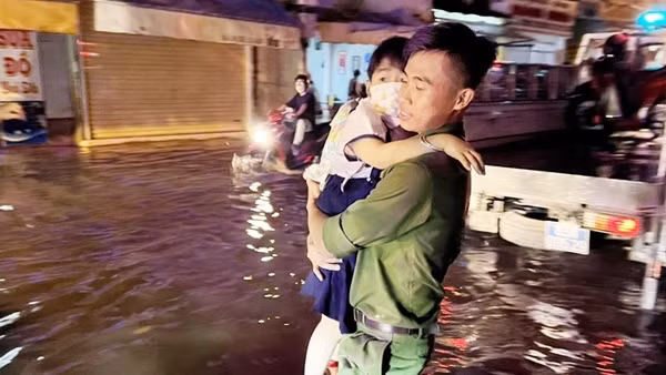 Công an dùng xe chuyên dụng đưa người dân thoát khỏi biển nước trên đường phố